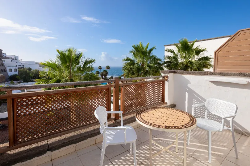 Terraza con mesas y sillas de la Gold Level Senior Suite Vista Océano en el Hotel Gran Tagoro