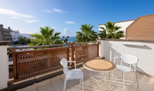 Terraza con mesas y sillas de la Gold Level Senior Suite Vista Océano en el Hotel Gran Tagoro